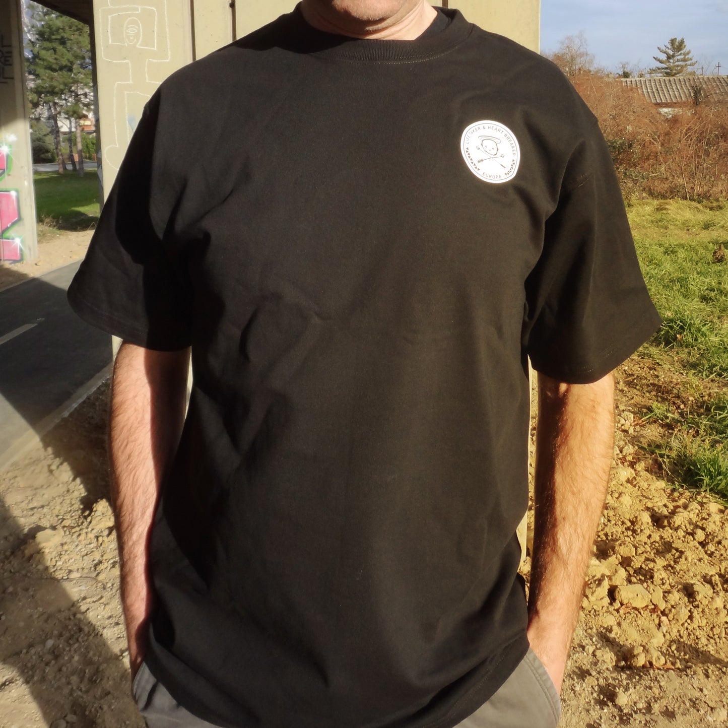 Black oversized t-shirt with Life Taker Heart Breaker circular badge logo